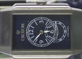 Croton brand men's wristwatch with a rectangular silver-tone case and a dark blu