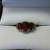  10K YELLOW GOLD WITH 3 OVAL CUT GARNETS AND 4 DIAMONDS .02CT EA