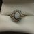  10K YELLOW GOLD WITH 1 OVAL CENTER OPAL SURROUNDED BY 12 SMALL ROUND OPALS