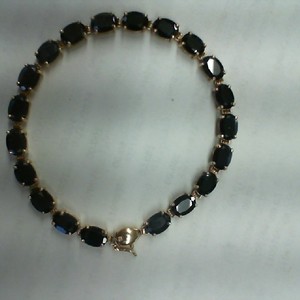 . .10K YELLOW GOLD TENNIS BRACELET WITH 20 OVAL CUT SAPPHIRES .75CT EA